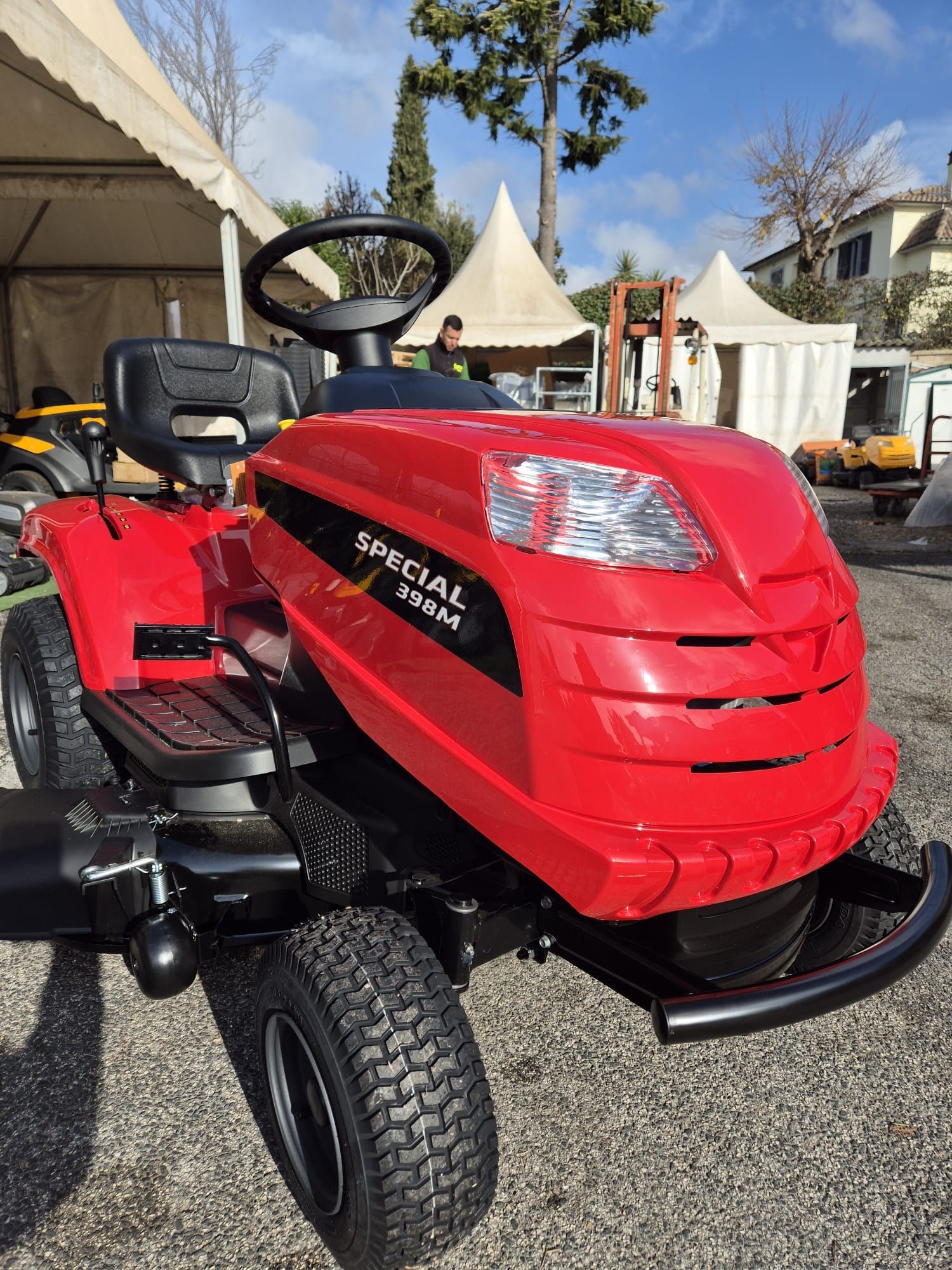 Tosaerba rosso con operatore a bordo e etichetta