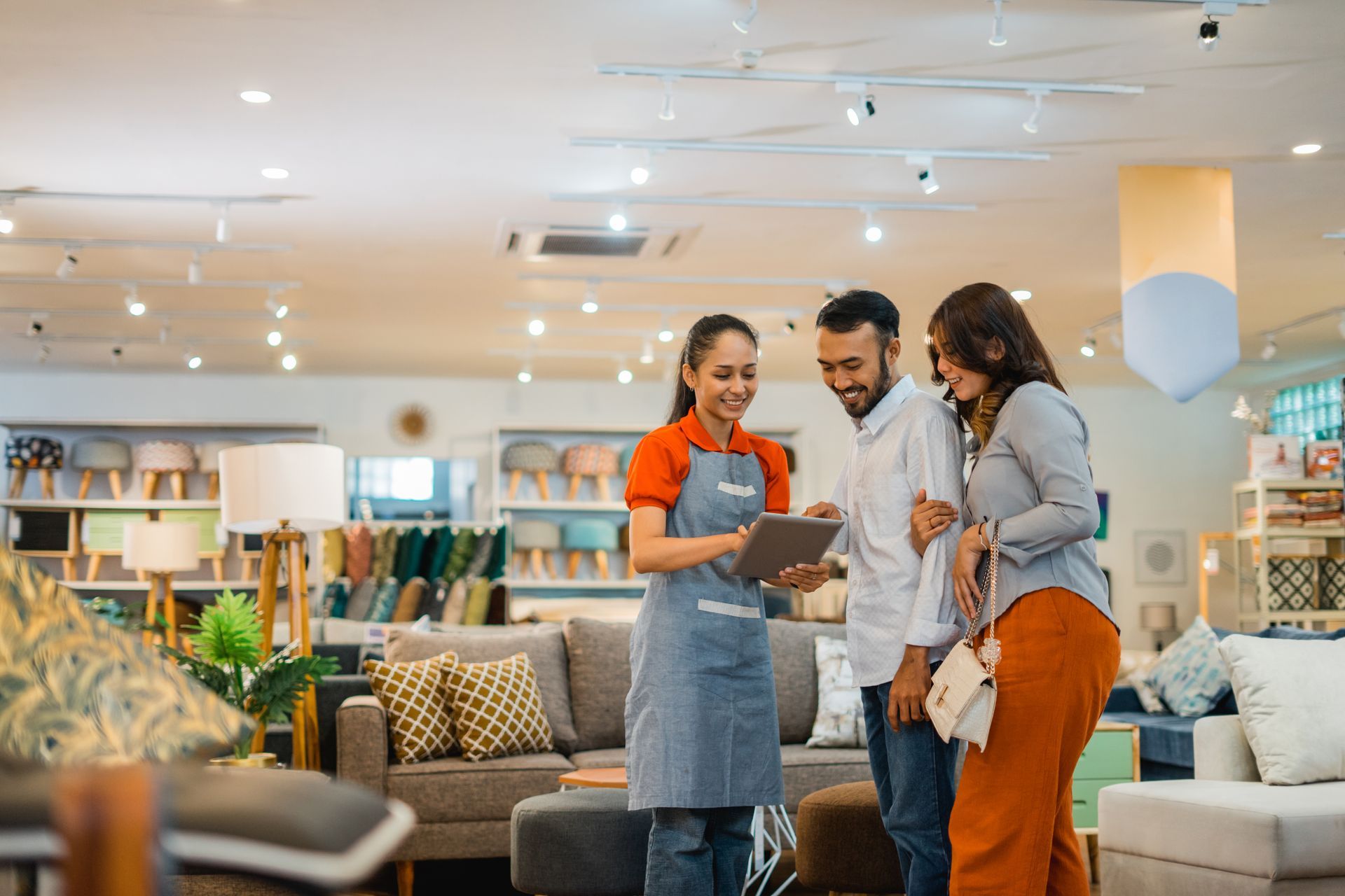 Female shop assistant serving a husband and wife customer.