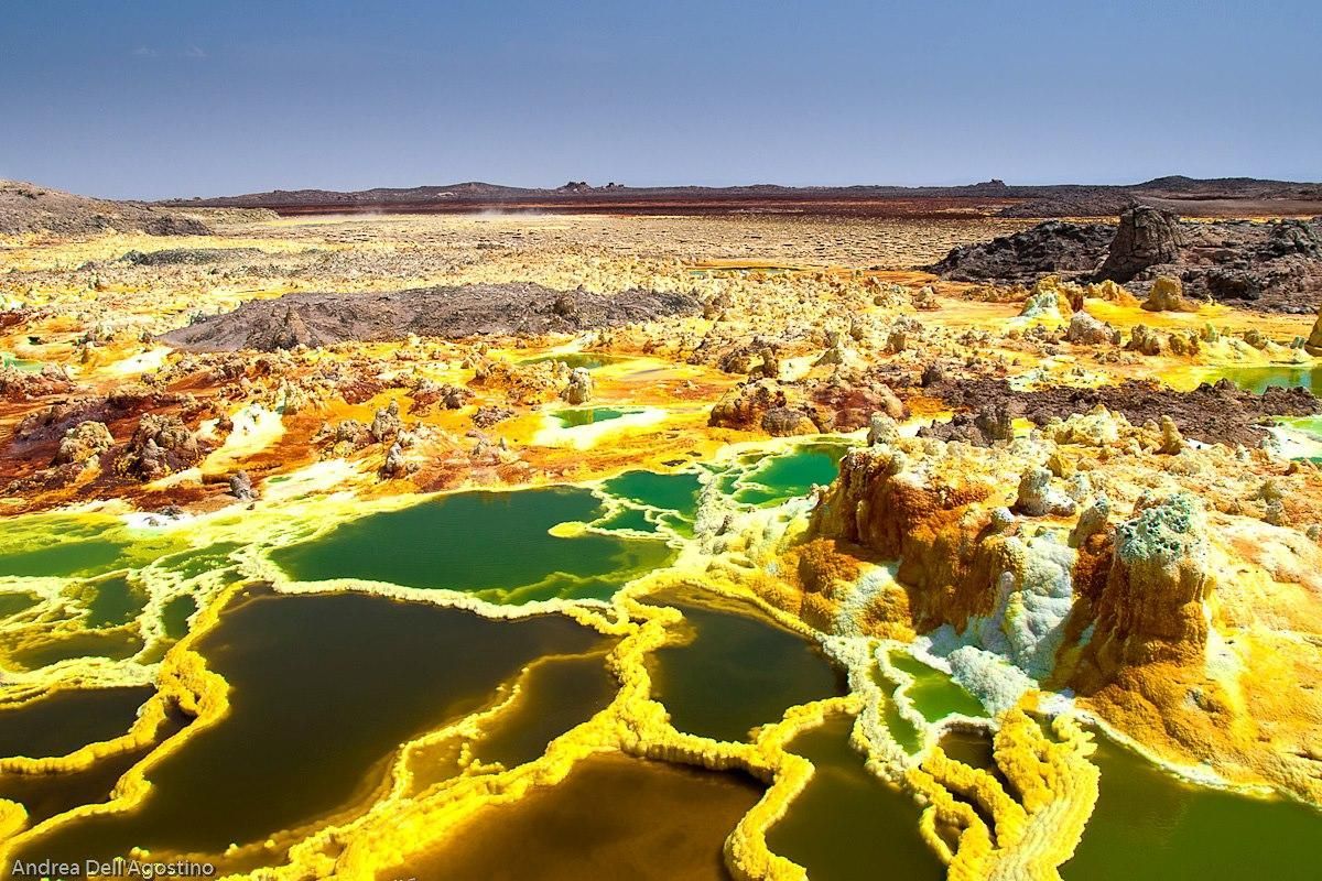 Dallol, Ethiopia Bright yellow sulfur terraces around green acidic pools in a barren geothermal landscape
