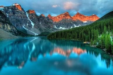 Moraine Lake, Banff Turquoise alpine lake reflecting snowy peaks and glowing orange mountain tops at sunset