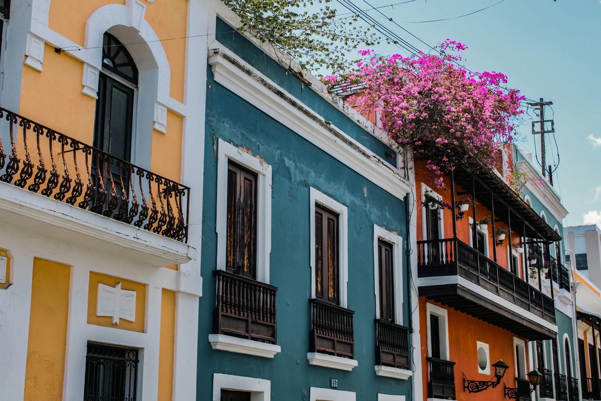 Colourful Cartagenian colonial street with blue and white buildings and blooming pink bougainvillea