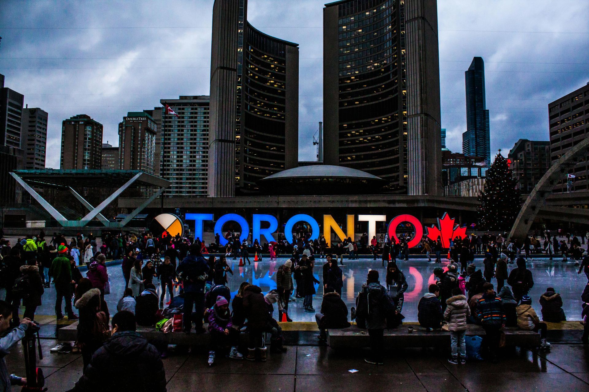 Toronto City Hall and skating rink with people in front of a colorful