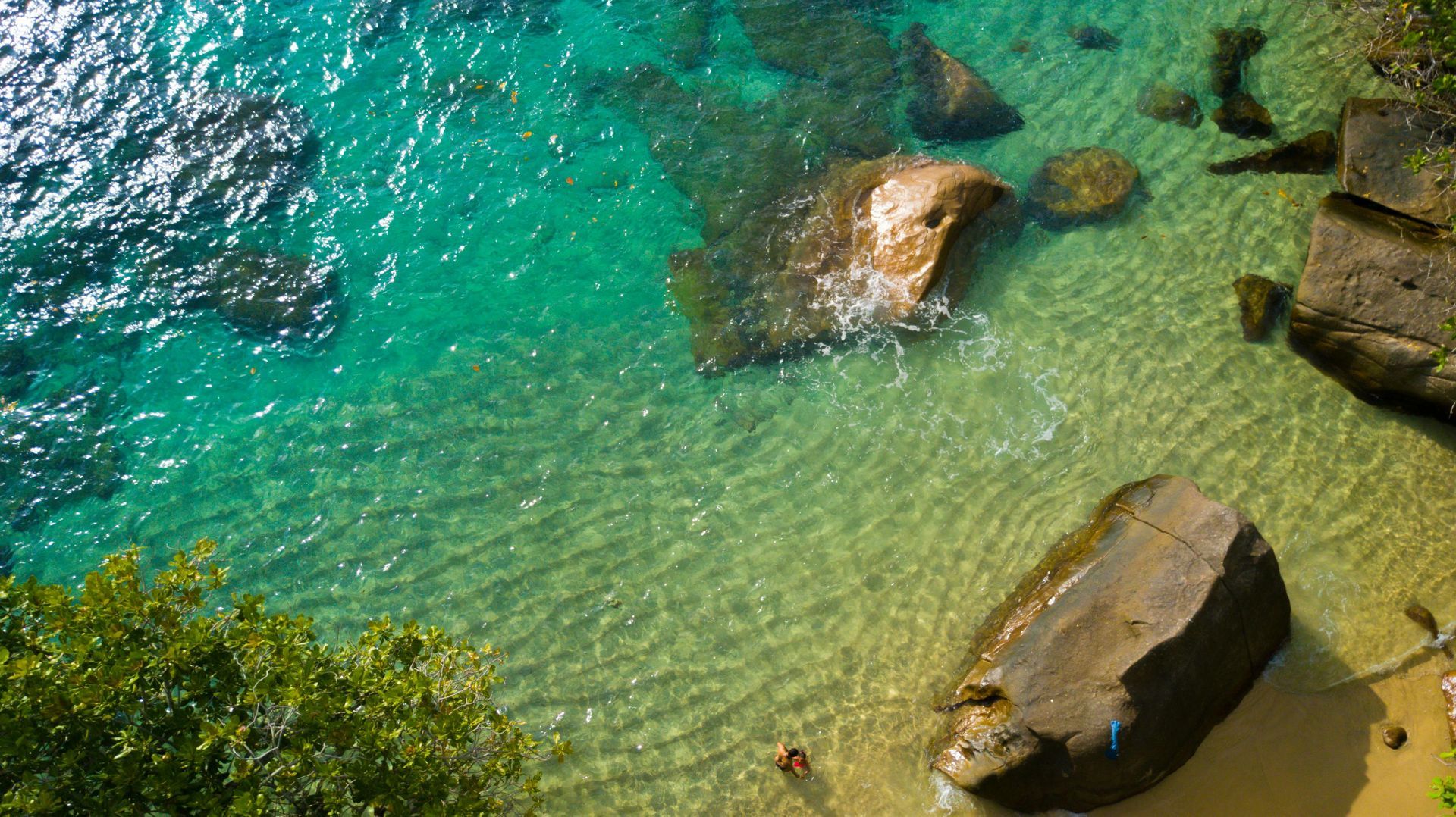 Clear turquoise water over rocks; view from above.