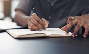 A person writing in a notebook