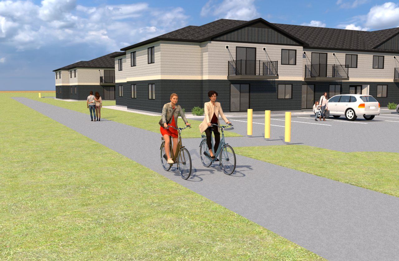 A couple of people are riding bicycles down a path in front of a building.