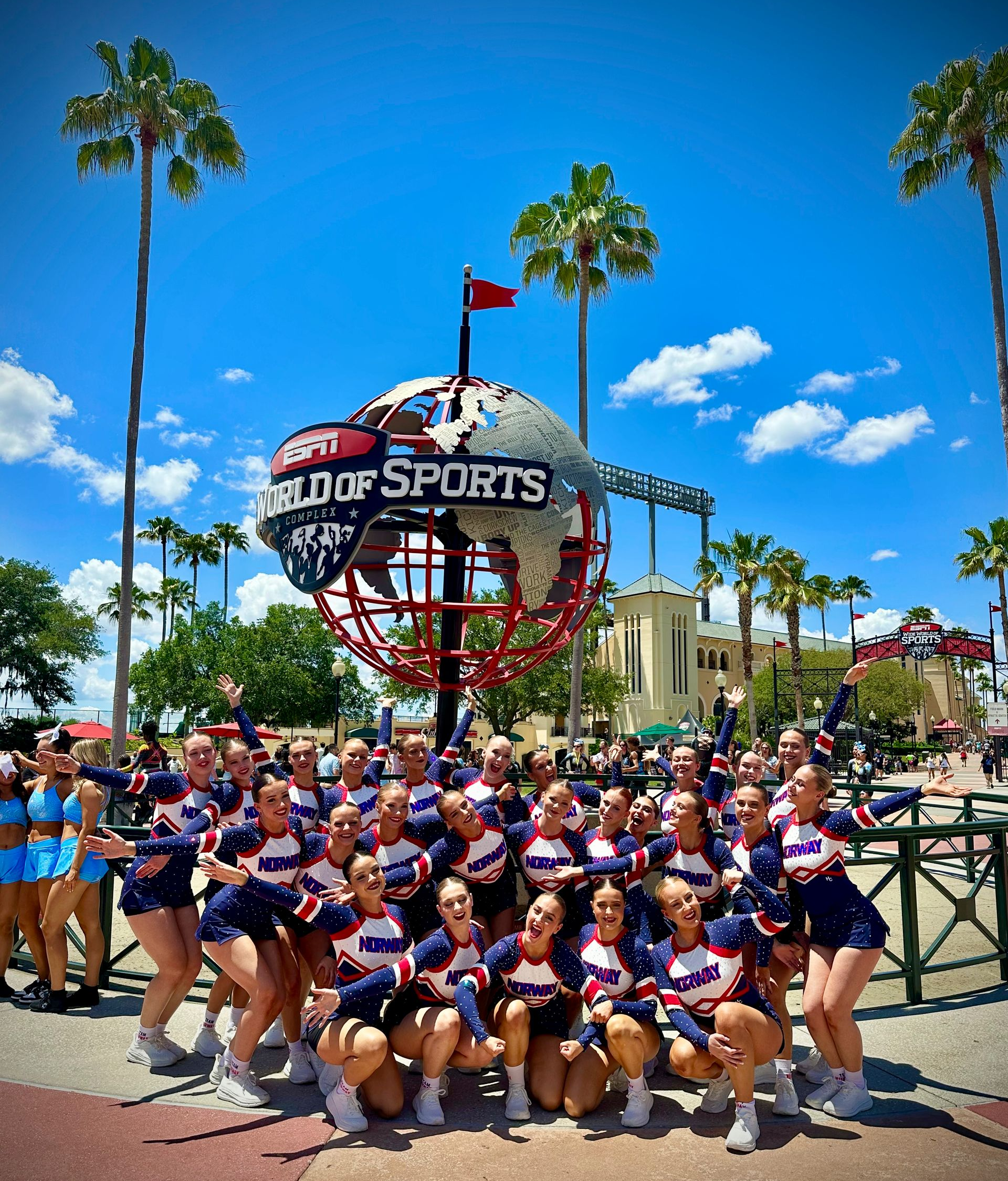Cheer squad posing in front of the Universal Studios globe on a sunny day