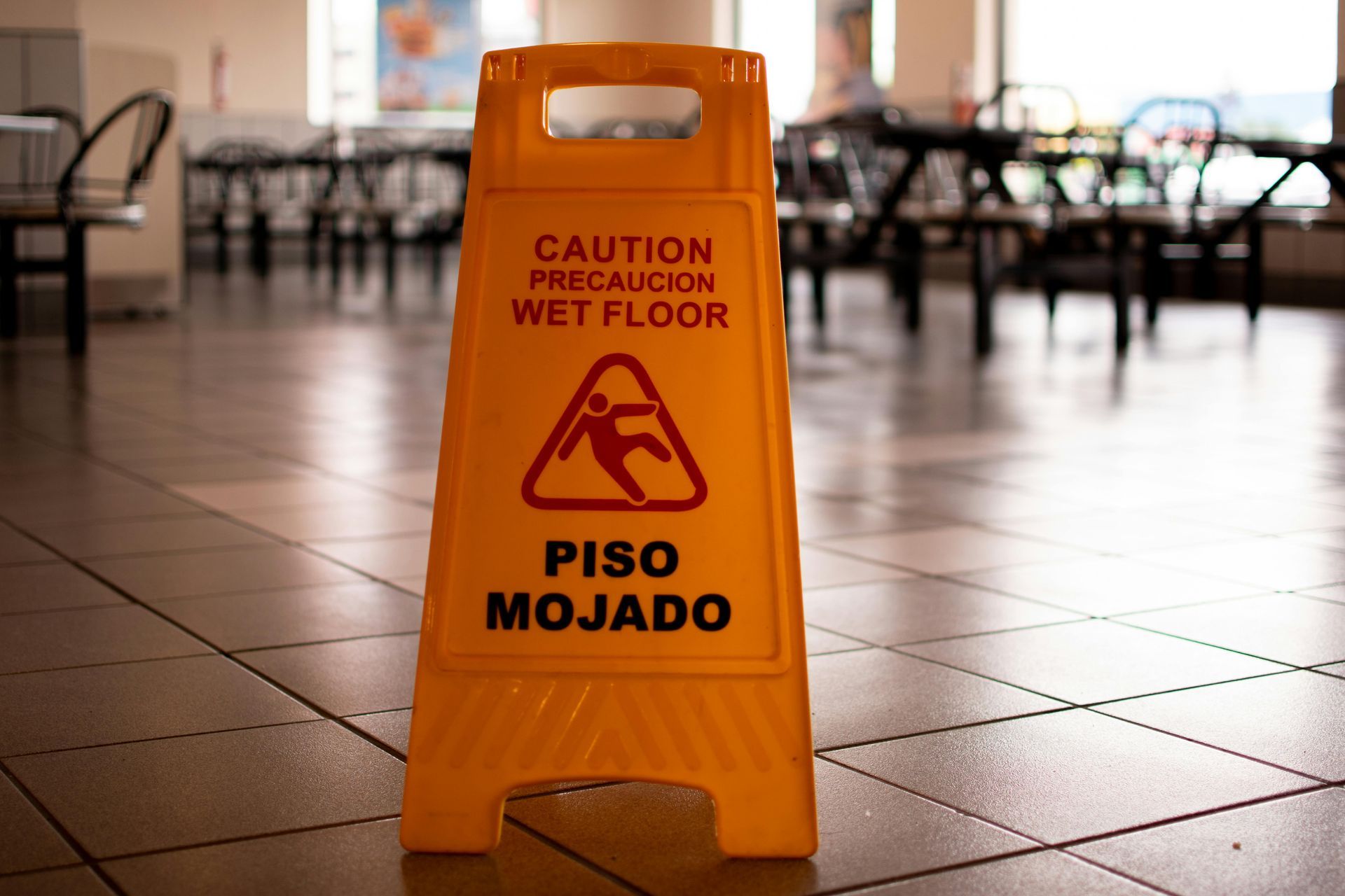 A yellow caution sign is on the floor of a diner.
