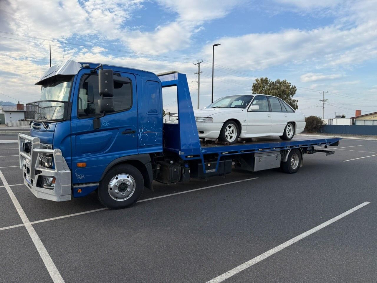 A White Flatbed Tow Truck Transporting a Silver Pickup Truck — AAA ULTRA TOWING in Mornington, TAS