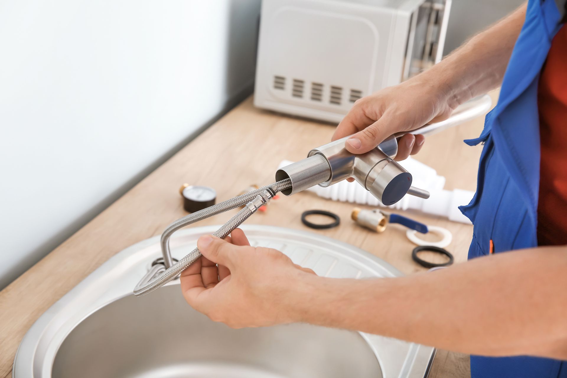Hands using a spray gun to clean a sink in a bathroom sink area