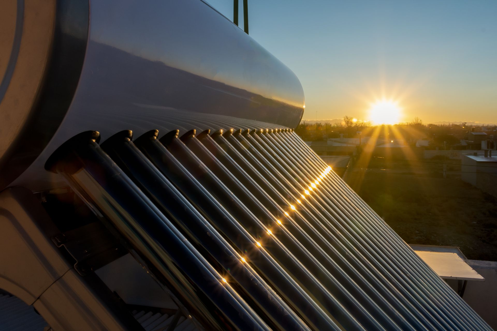 Sunlit solar water heater panels on a rooftop at sunrise