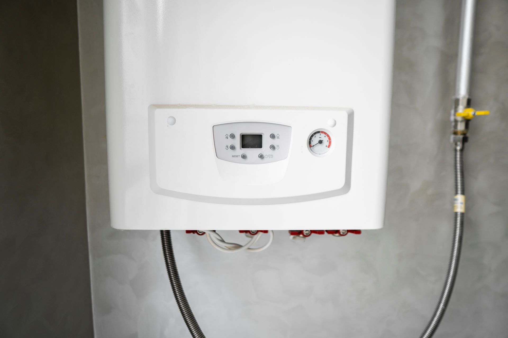 Wall-mounted white water heater with digital control panel and connected pipes.