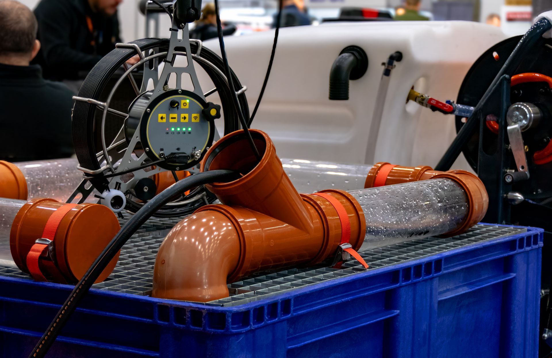 Industrial pipe assembly with orange pipes, gauges, and blue crates in a workshop