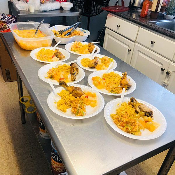 Plates of food are lined up on a stainless steel table