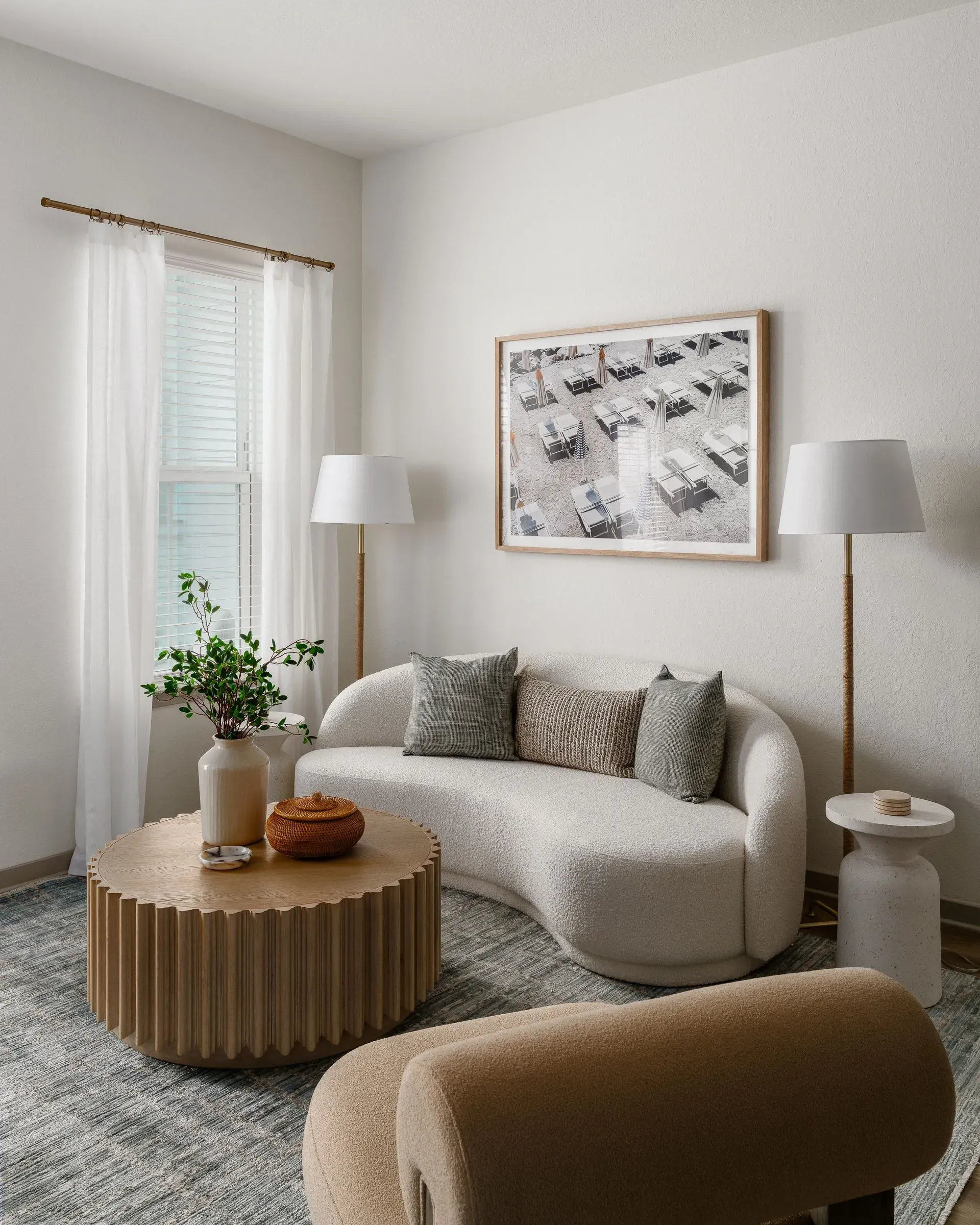 Living room with curved sofa, round coffee table, and abstract art.