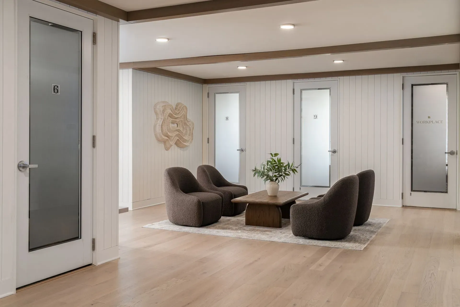 Modern seating area with frosted glass doors in the background.