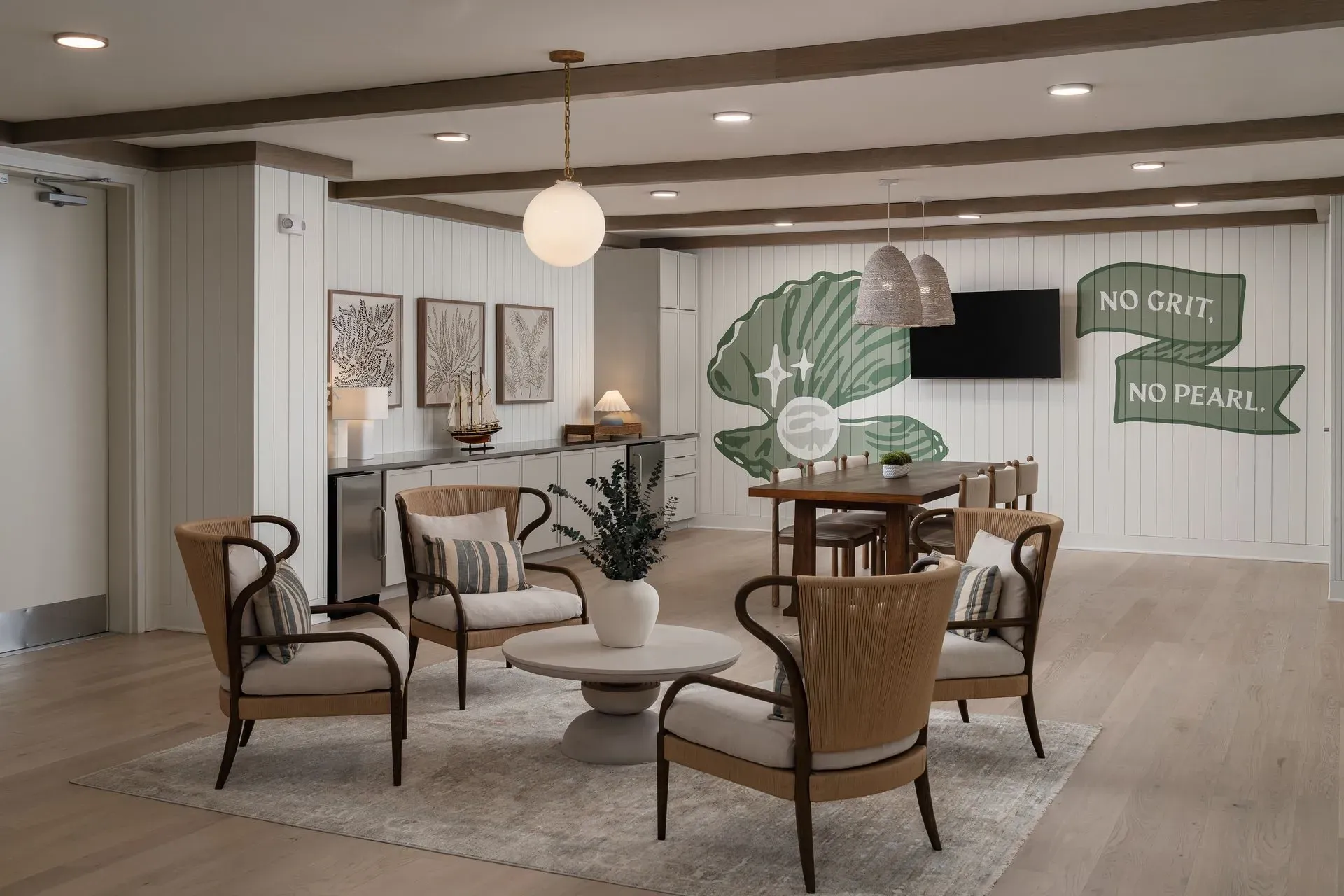 Seating area with chairs and coffee table in a community lounge with a large mural.