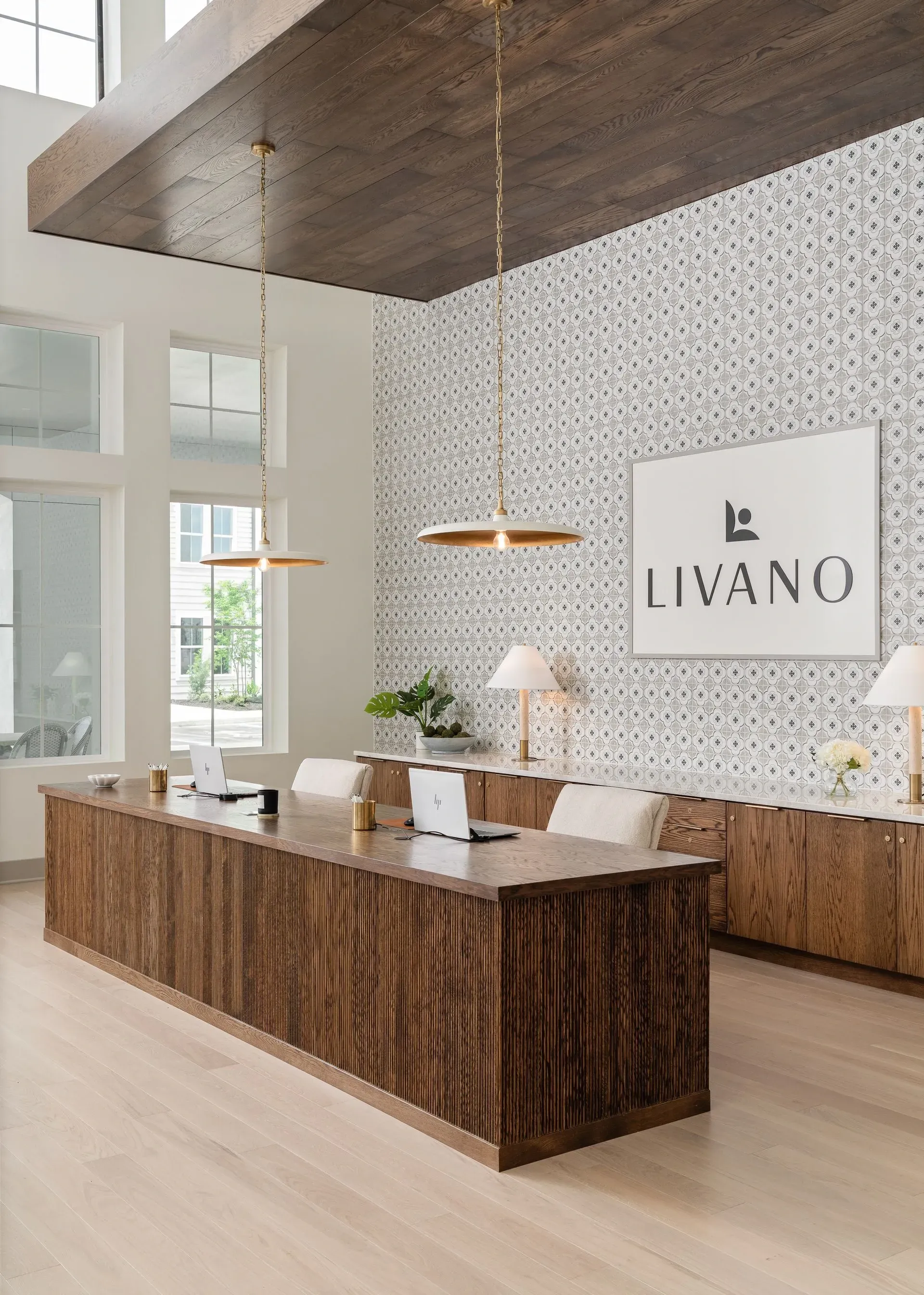 LIVANO property reception desk with laptops and modern decor.