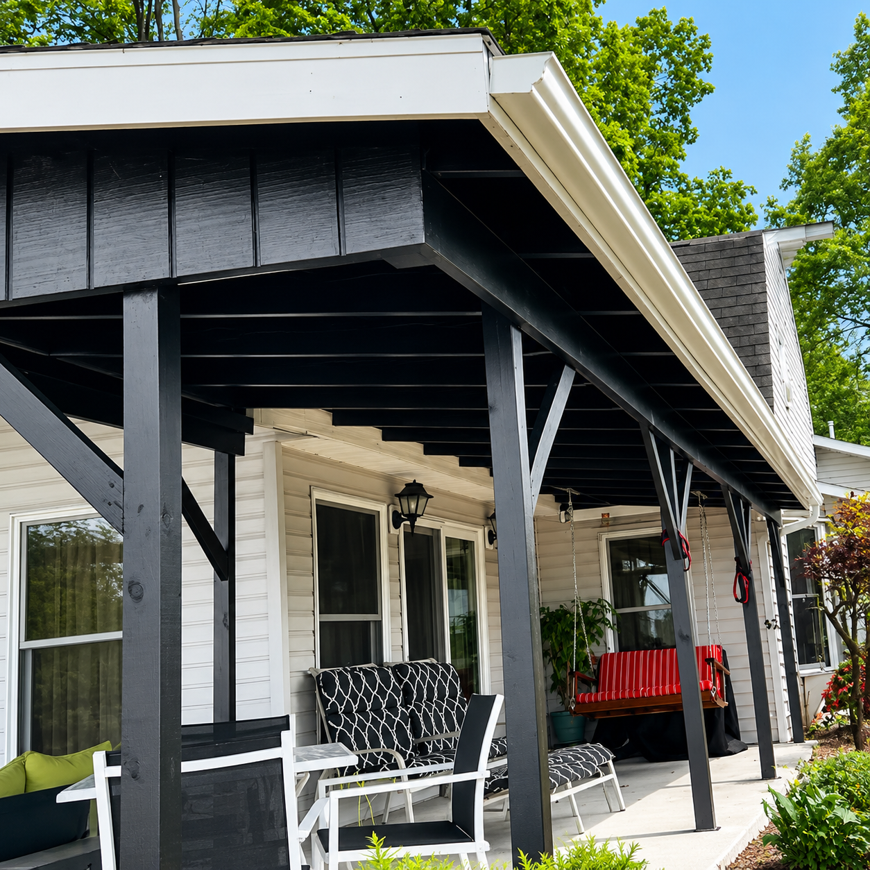 Black-and-white porch with rocking chairs and red bench on a white house under a shaded roof