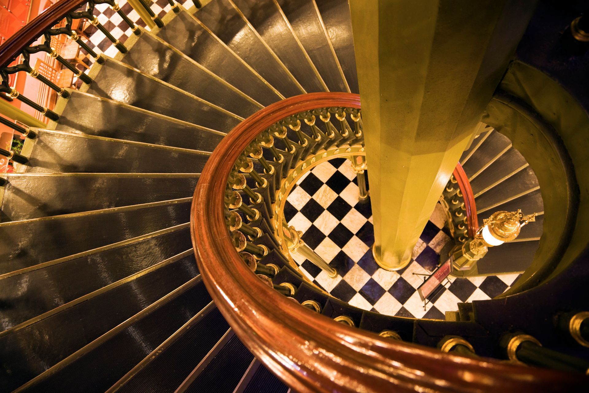 Looking down a spiral staircase with a checkered floor Looking down a spiral staircase with a checkered floor