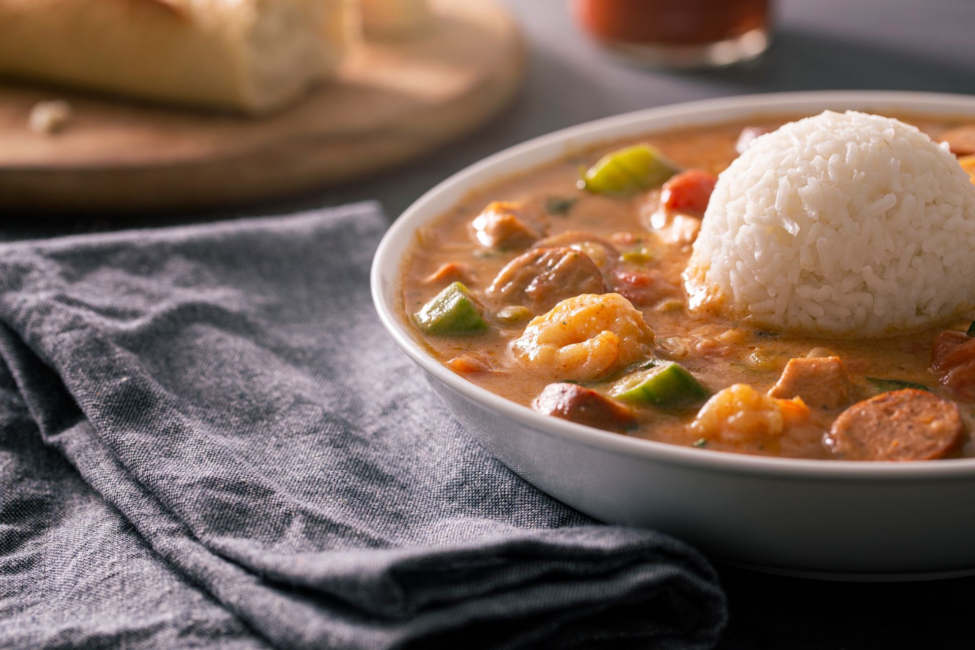 There is a bowl of gumbo with rice in it. There is a bowl of gumbo with rice in it.