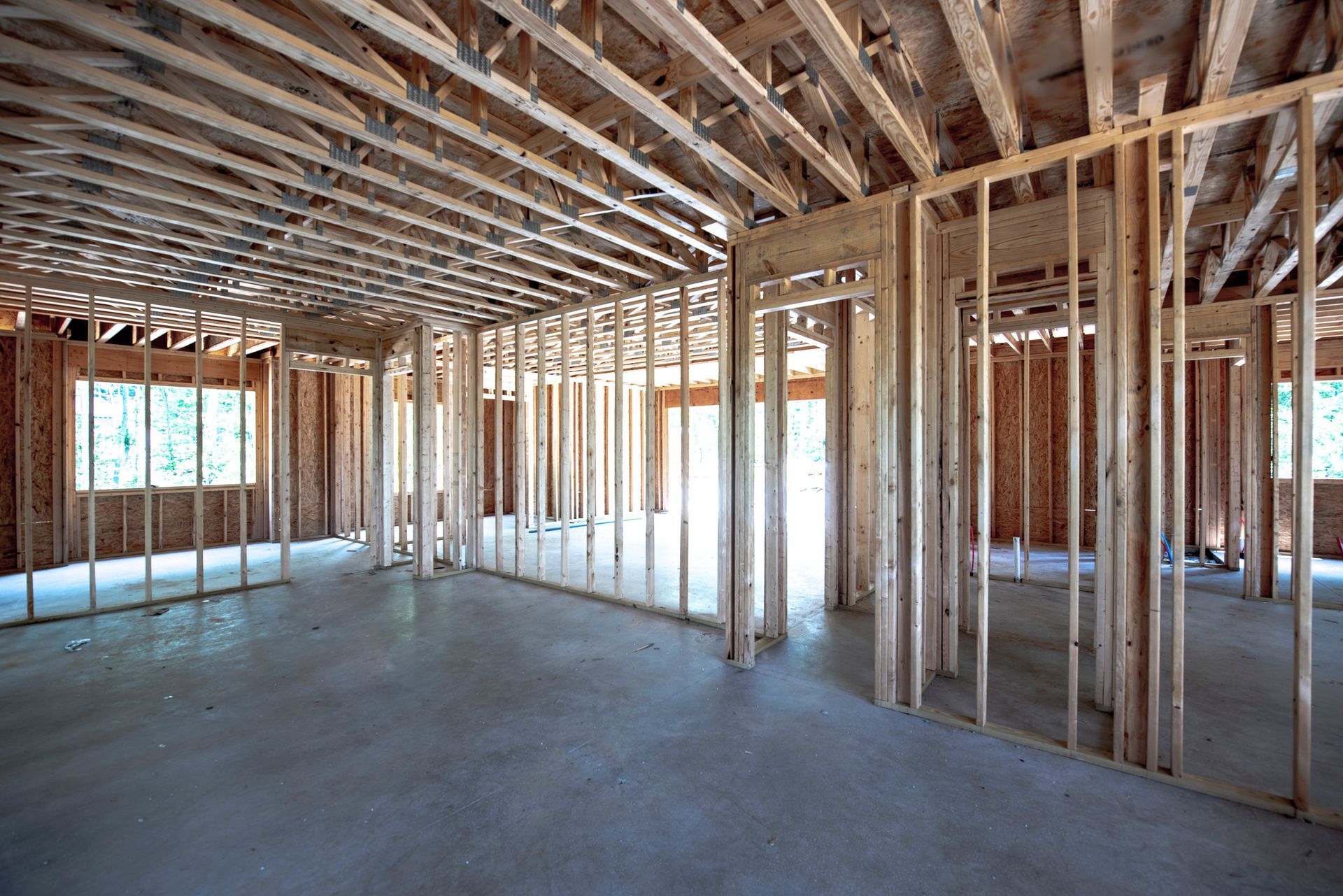 An empty room in a house under construction with wooden beams. An empty room in a house under construction with wooden beams.