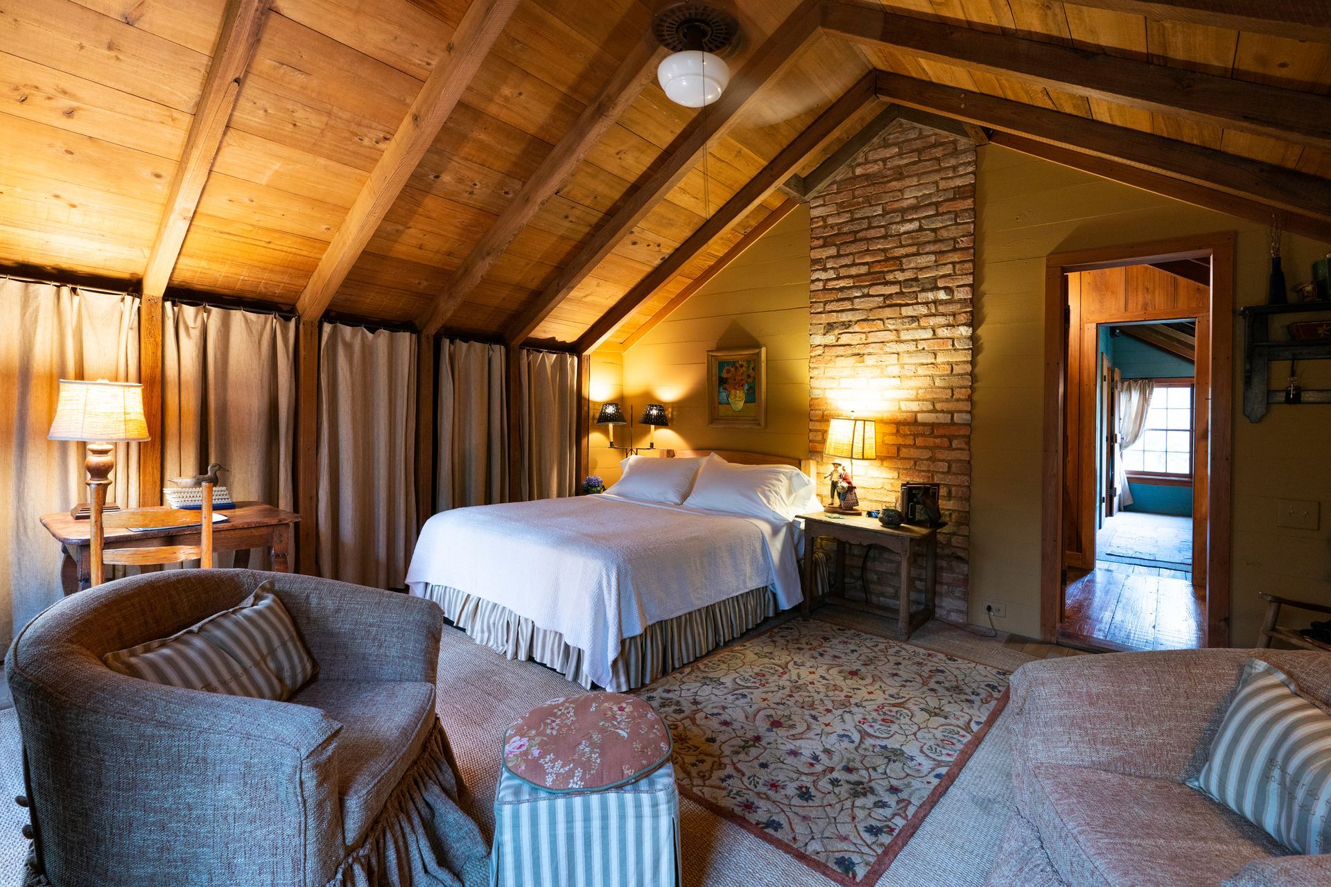 A bedroom with a bed , chairs , and a fireplace. A bedroom with a bed , chairs , and a fireplace.