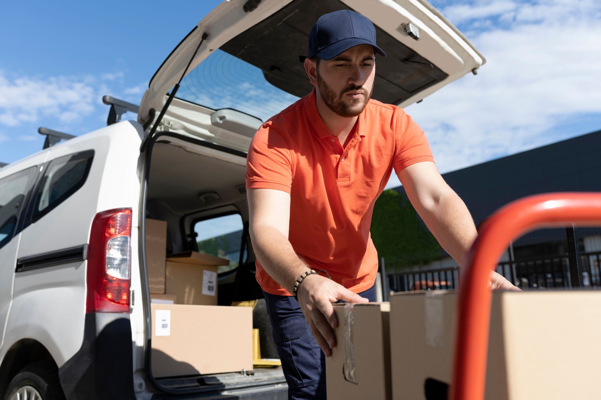 A delivery man is loading boxes into the back of a van. A delivery man is loading boxes into the back of a van.