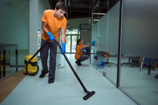 A man and a woman are cleaning an office with a vacuum cleaner. A man and a woman are cleaning an office with a vacuum cleaner.