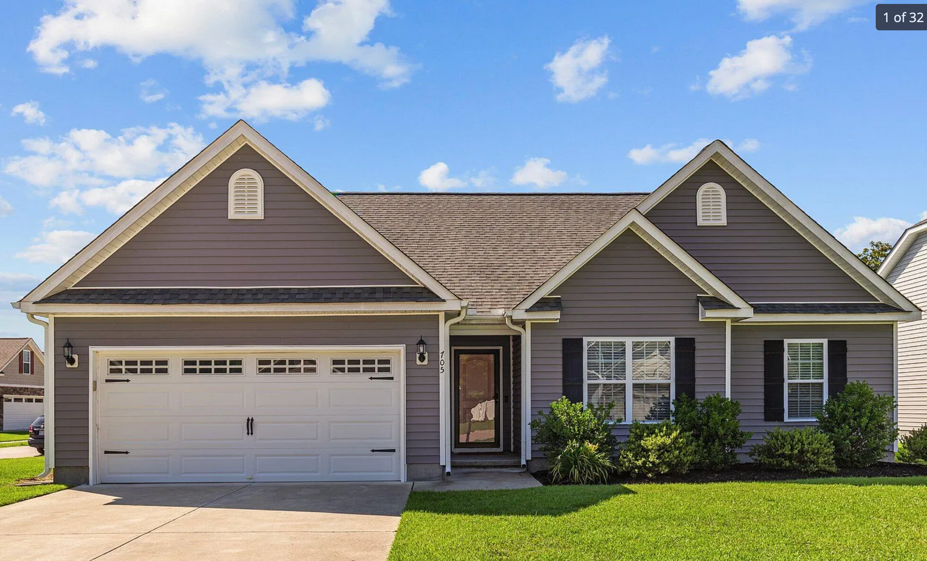 A large gray house with a white garage door