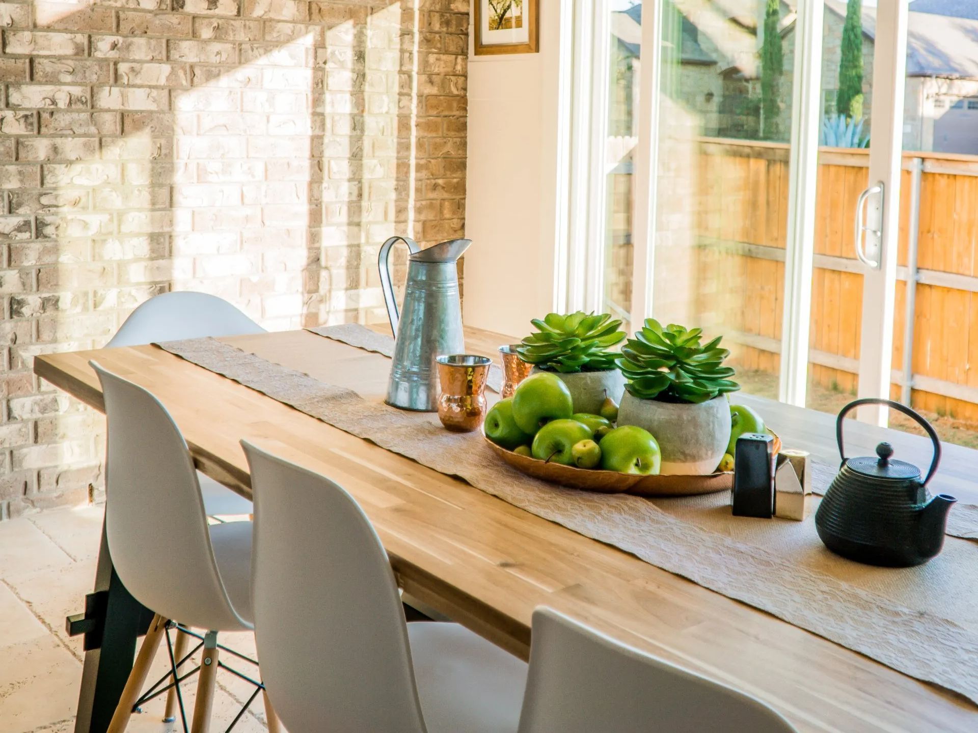 Meeting table with chairs, platter with fruit and succulents, tea kettle