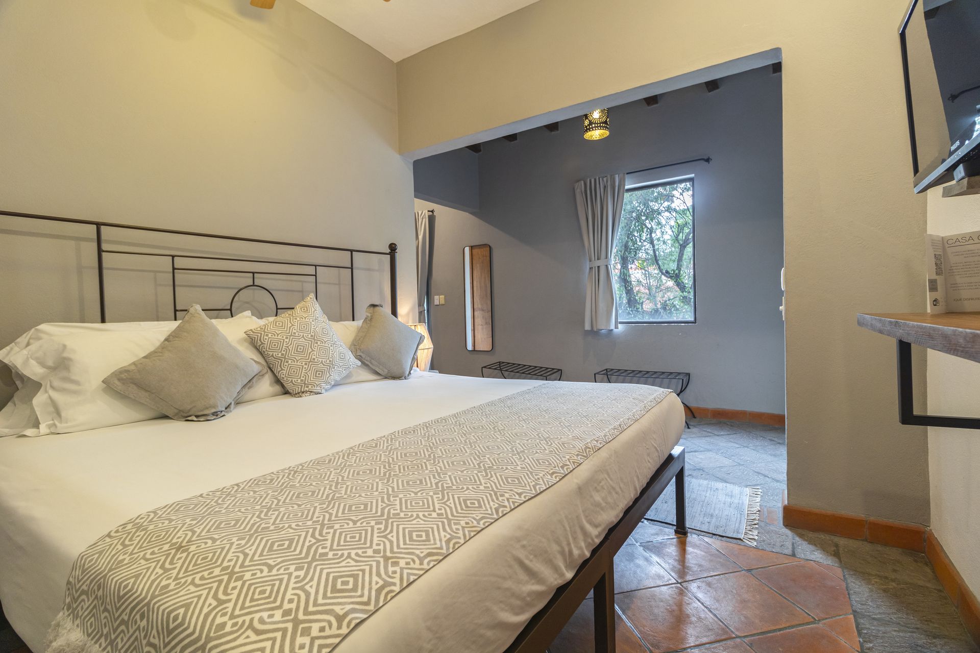 A hotel room with a king size bed and a television.