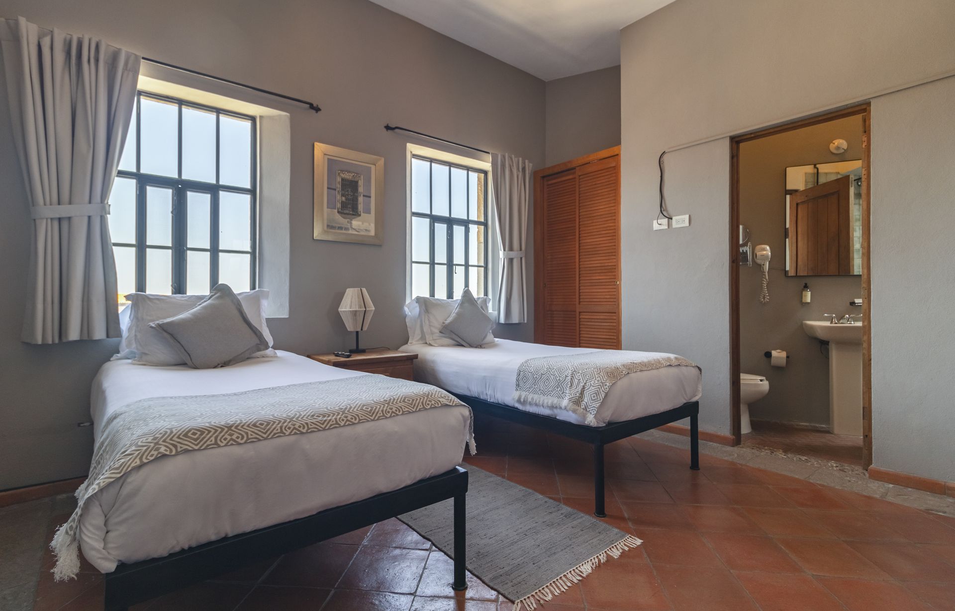 A hotel room with two beds and a bathroom.