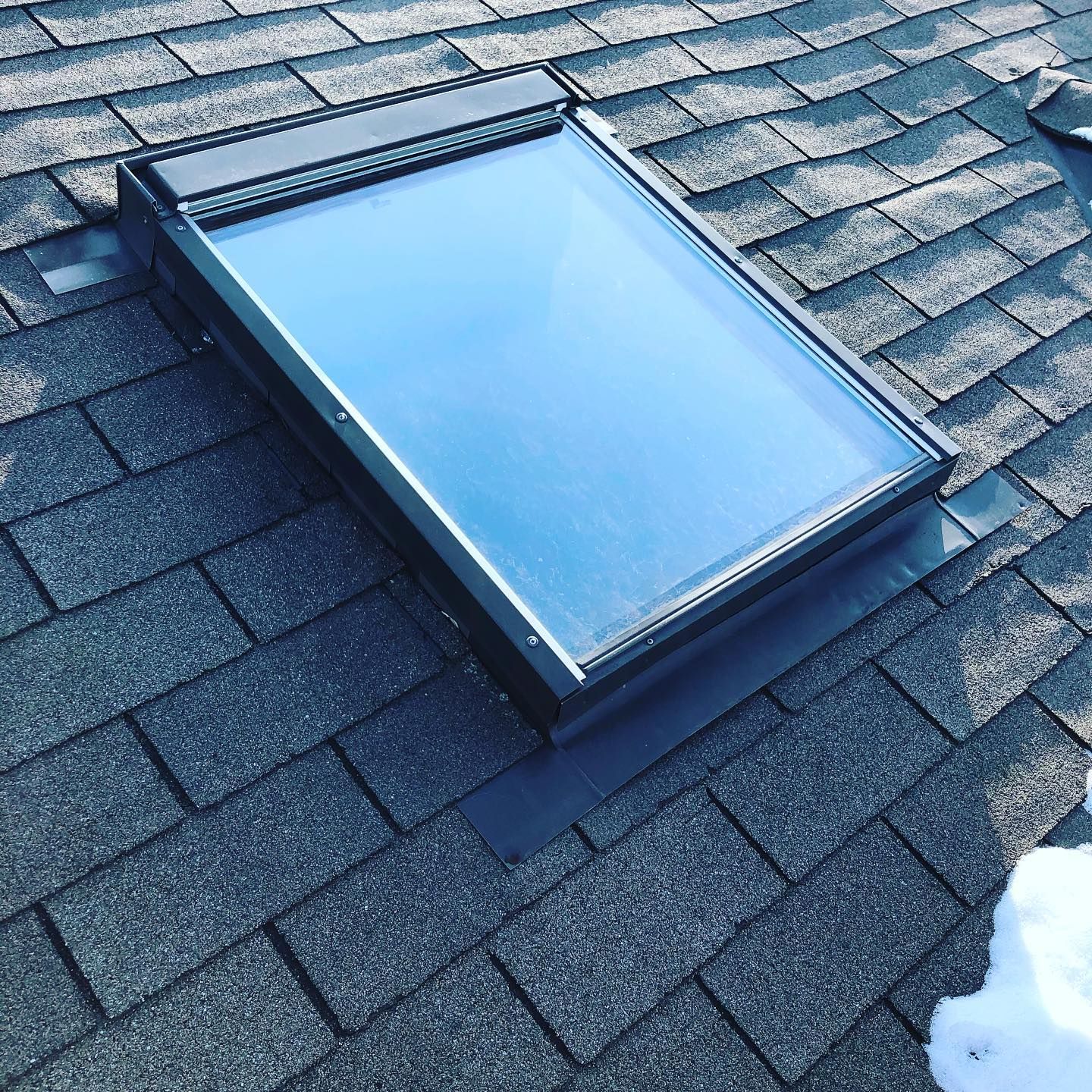 A skylight sitting on top of a brick roof