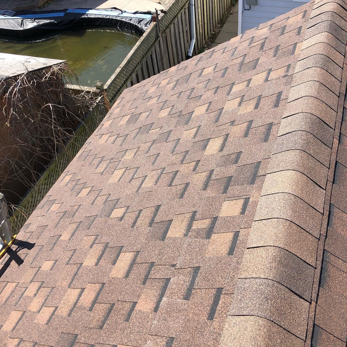 A close up of a roof with a fence in the background
