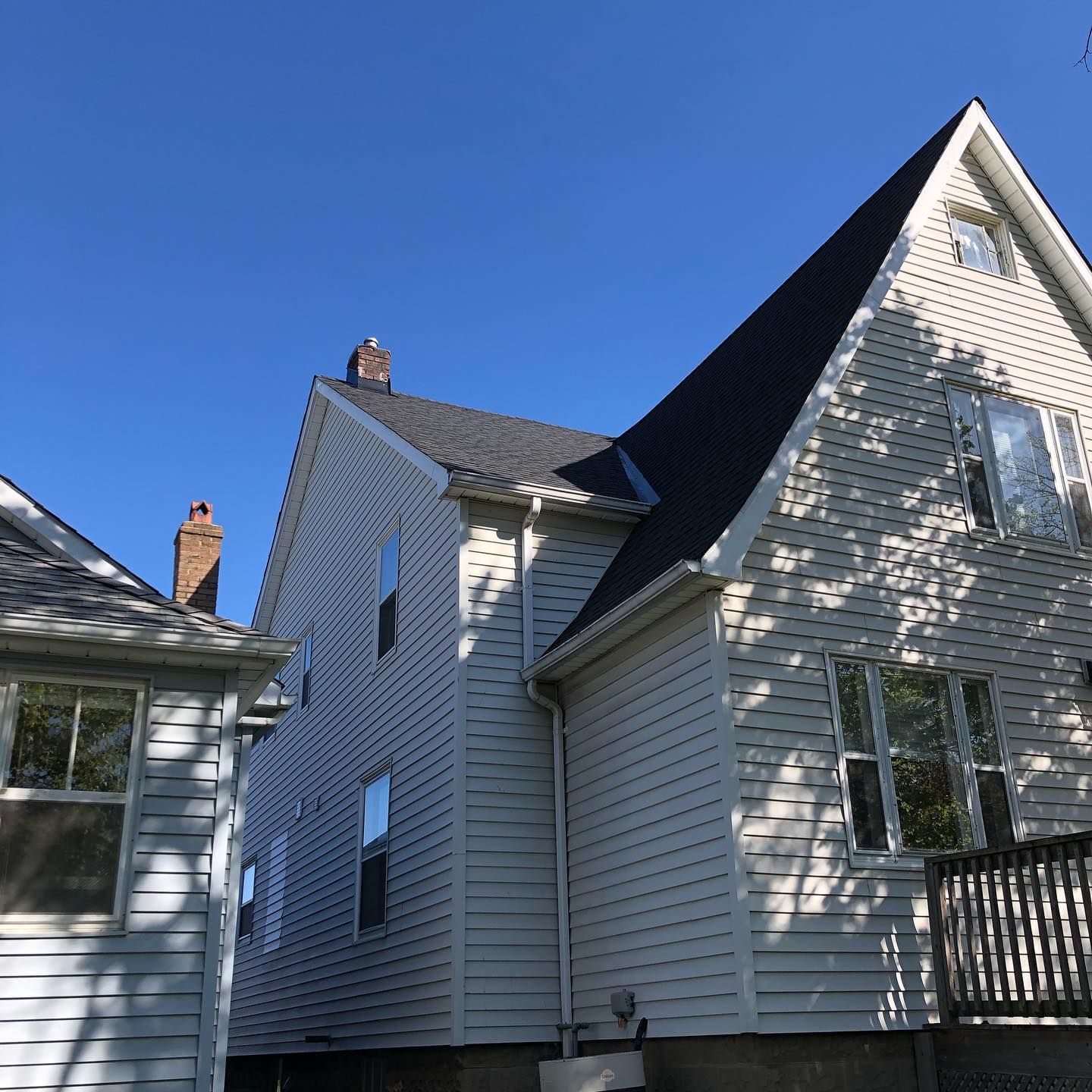 A white house with a black roof and a chimney