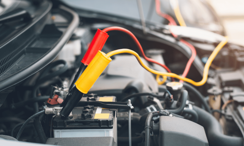 Car battery with diagnostic leads connected for electrical system testing
