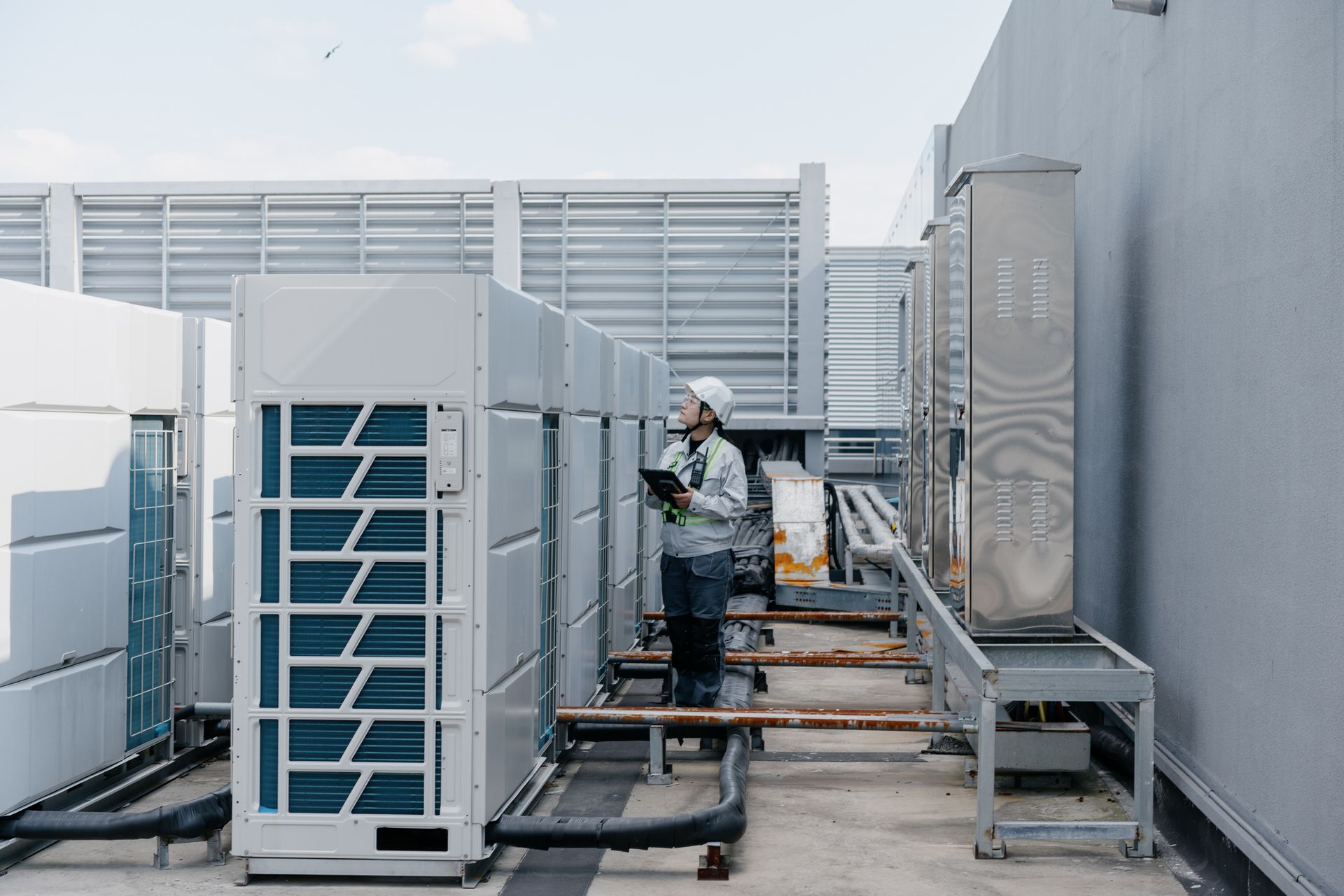 A man stands beside a large air conditioning unit, showcasing Triton Mechanical's HVAC system installation in High Point, NC. A man stands beside a large air conditioning unit, showcasing Triton Mechanical's HVAC system installation in High Point, NC.