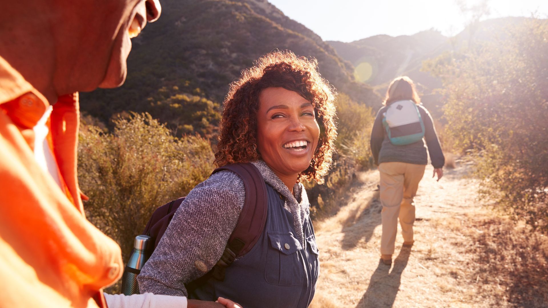 people on a sunlit hiking trail