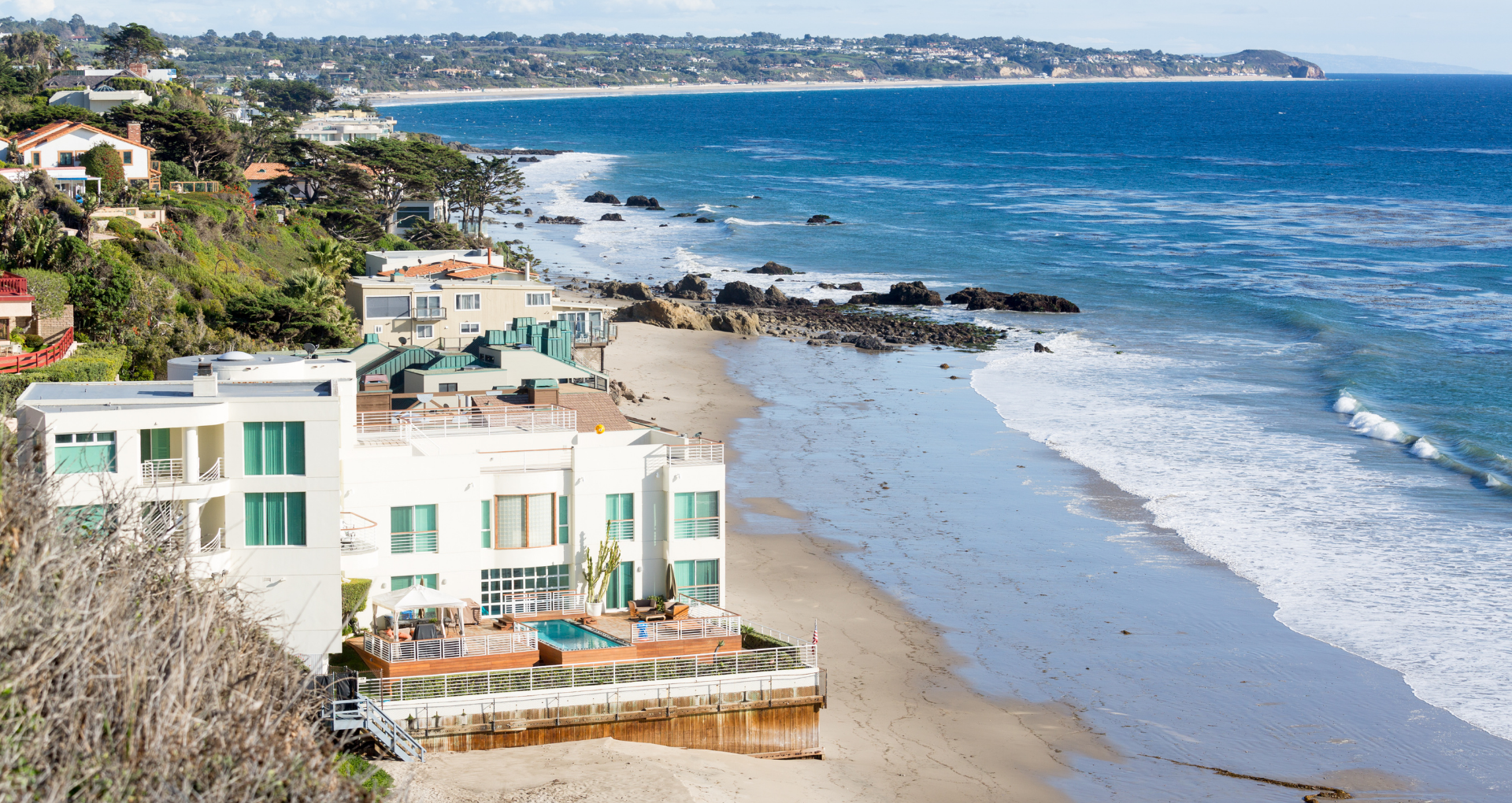 an aerial view of a beach with a house in the foreground .