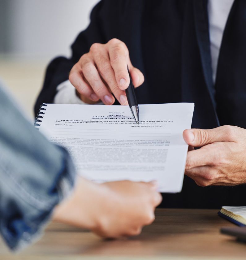 A man is holding a pen over a piece of paper.