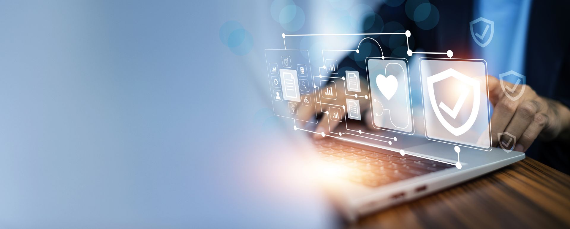 Hands typing on a laptop with glowing security icons and a shield over a blue background