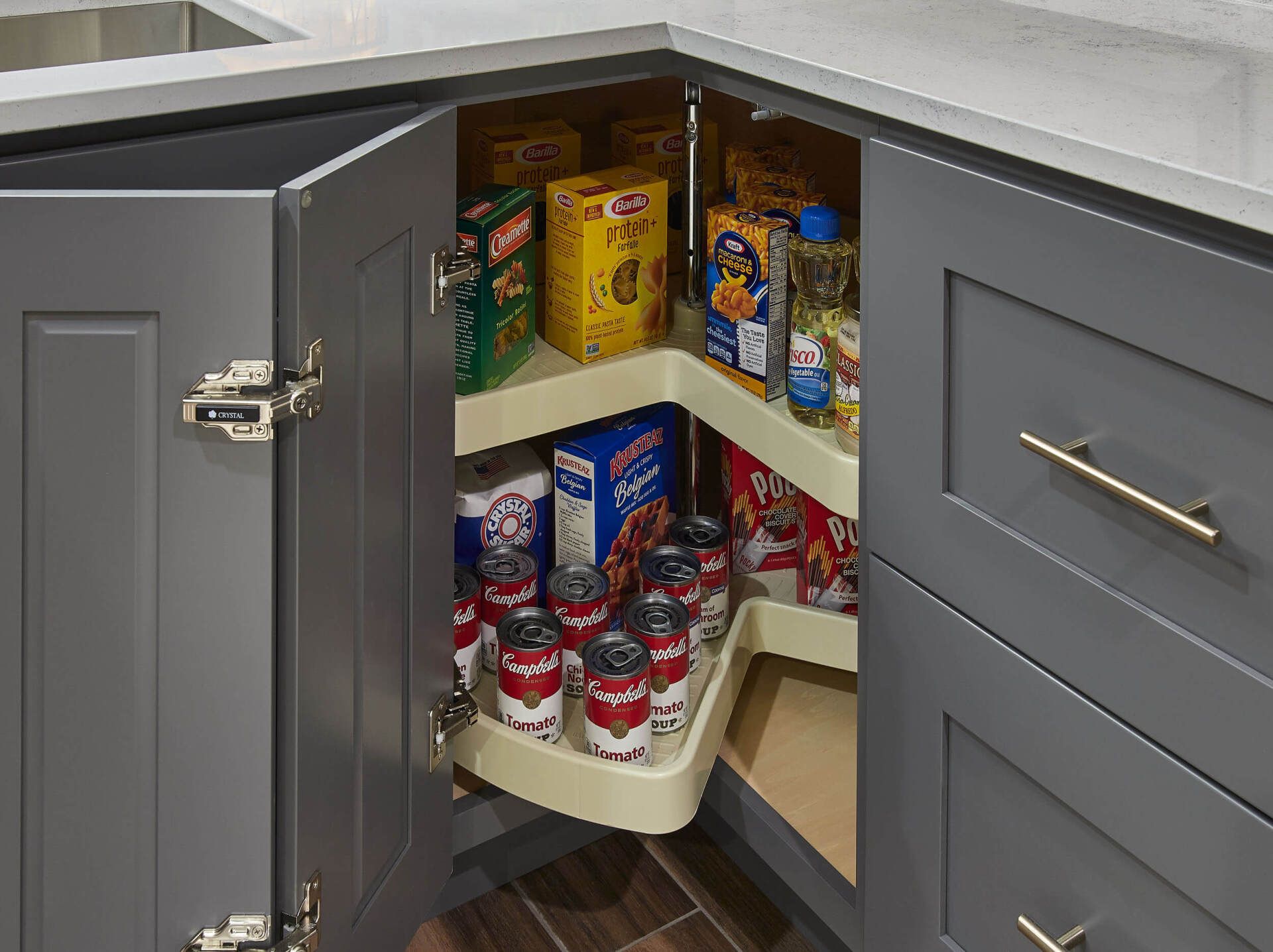 A kitchen pantry with a corner shelf filled with food.