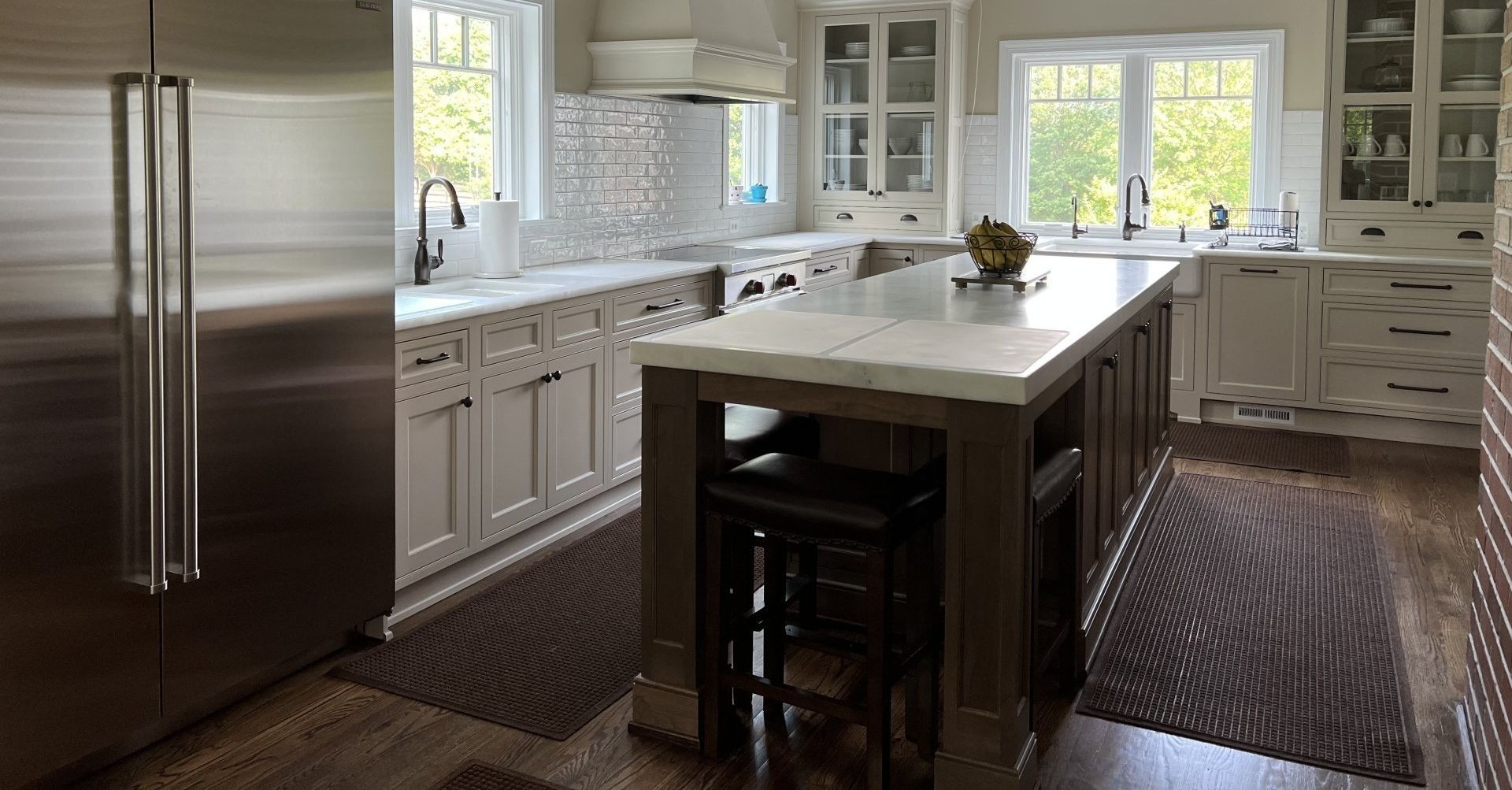 A kitchen with stainless steel appliances and a large island in the middle.