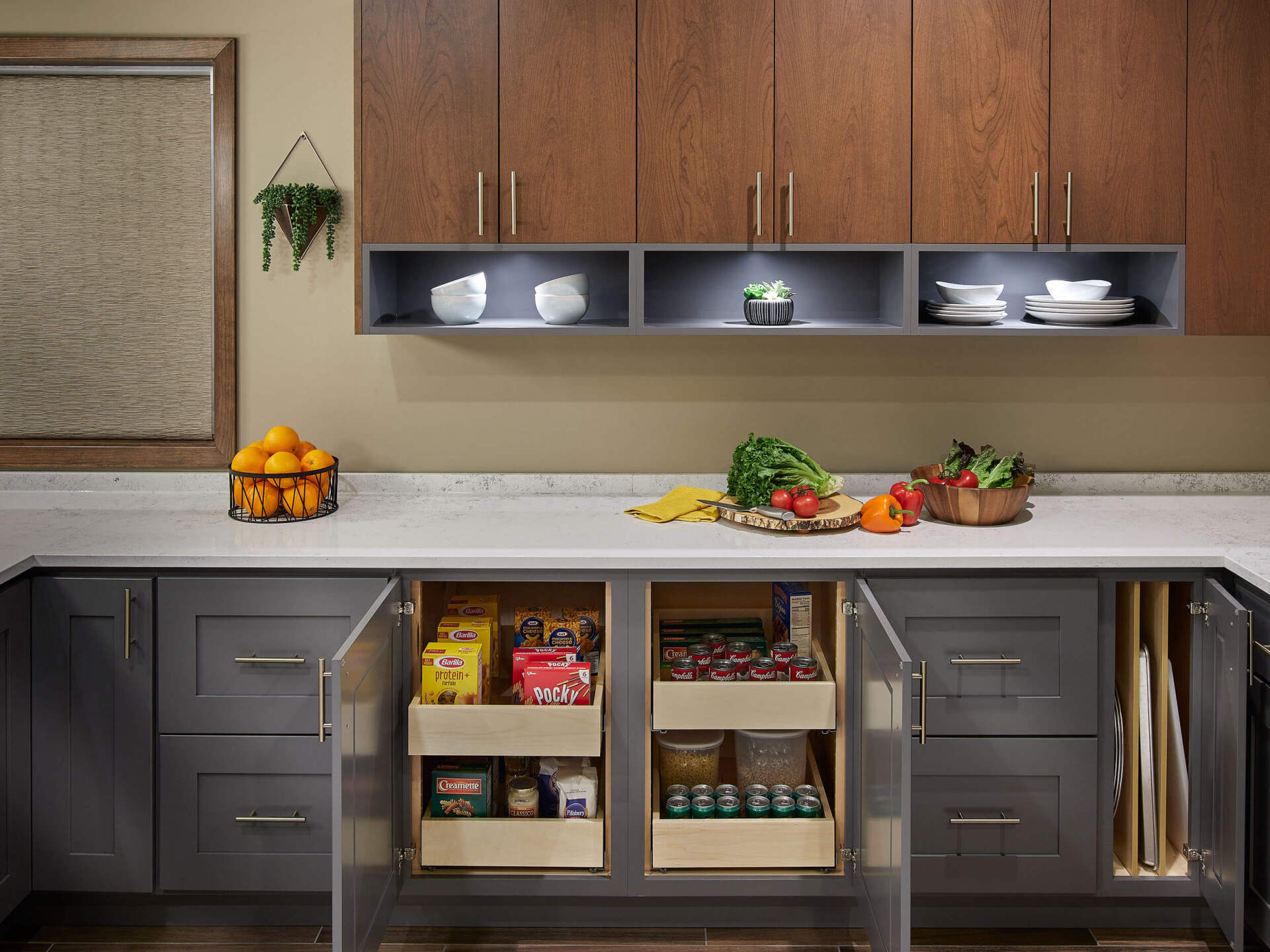 A kitchen with gray cabinets , wooden cabinets , and a counter top.