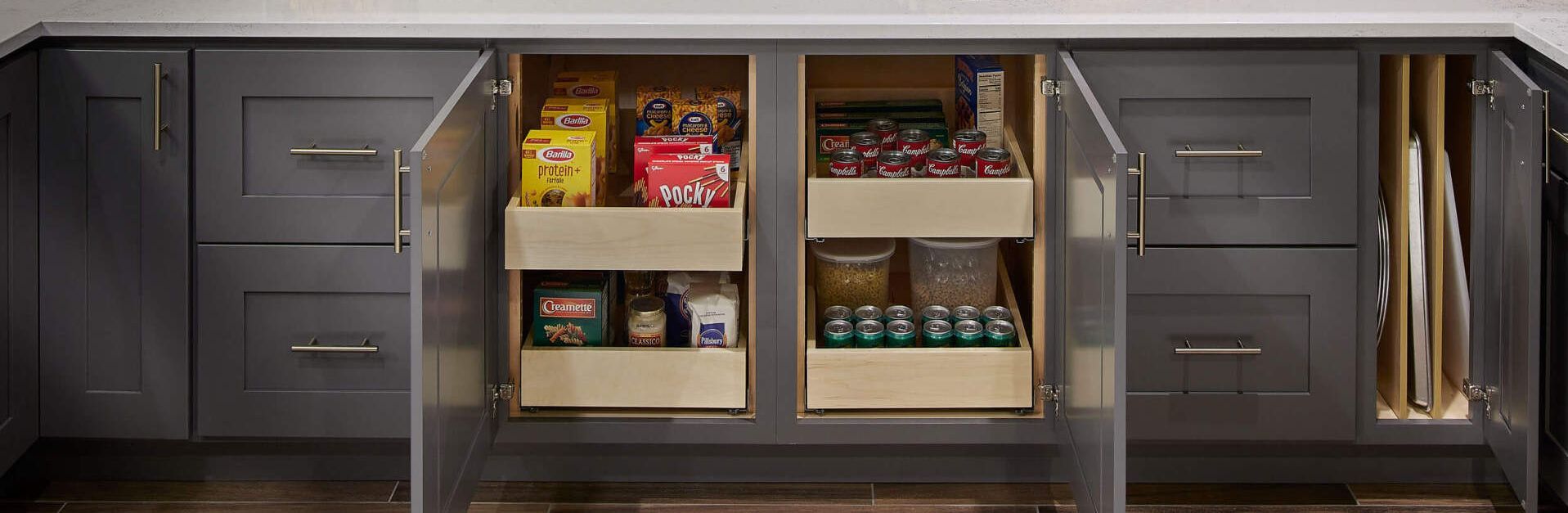 A kitchen with a lot of cabinets and drawers filled with food.