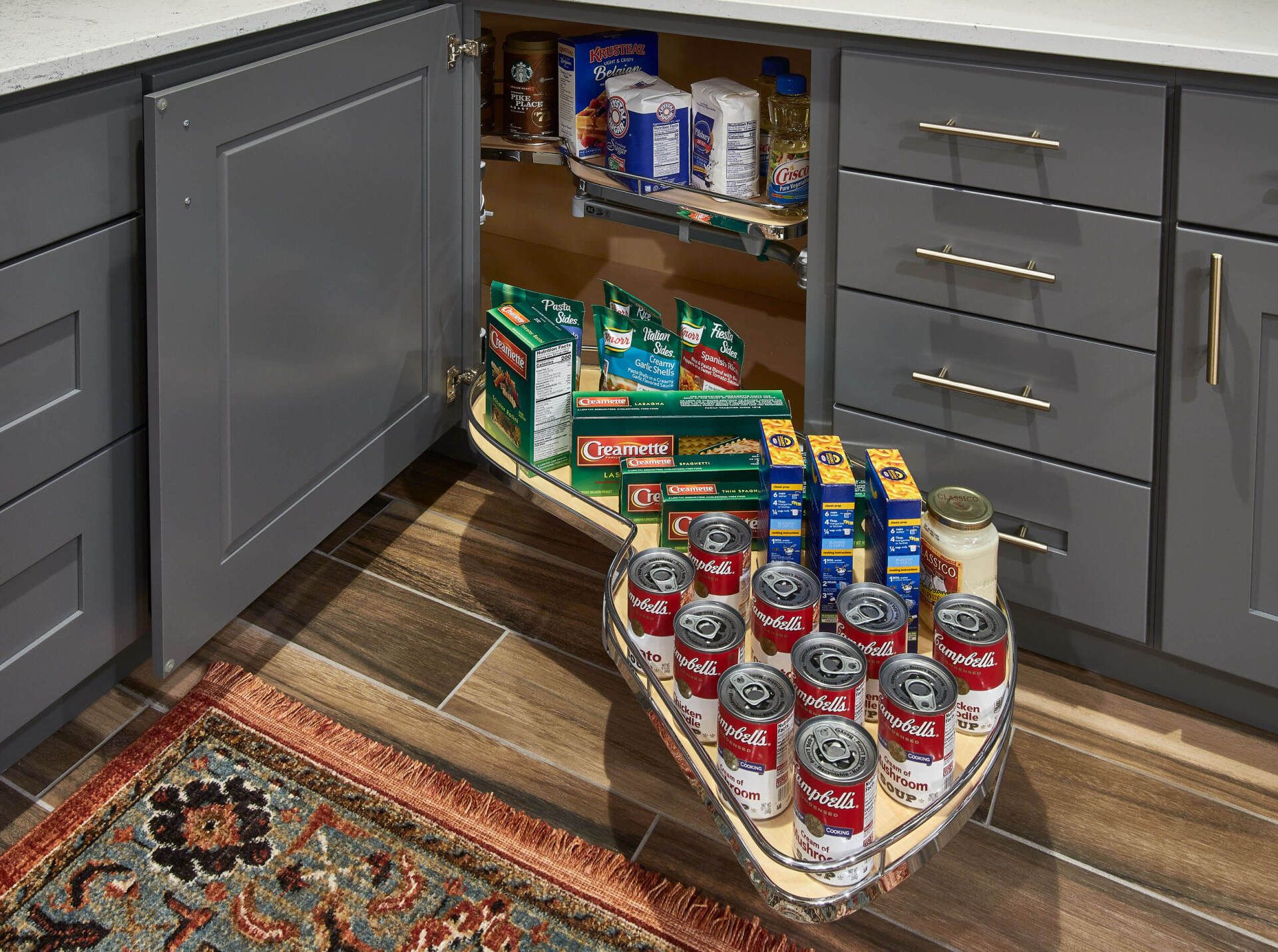 A kitchen with a pull out tray filled with canned food.