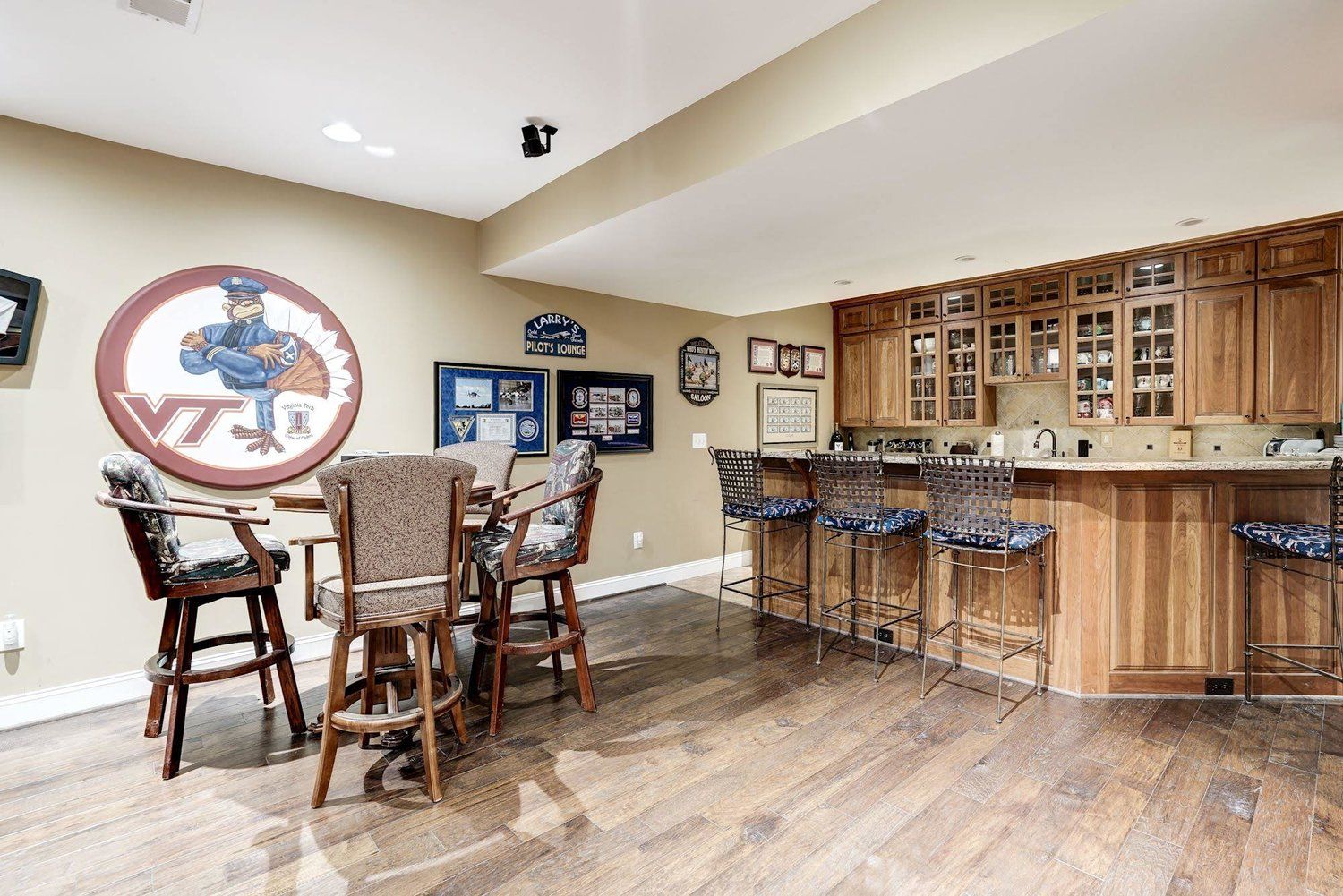 A basement with a table and chairs and a bar.