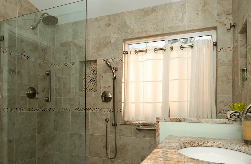 A bathroom with a walk in shower and a sink