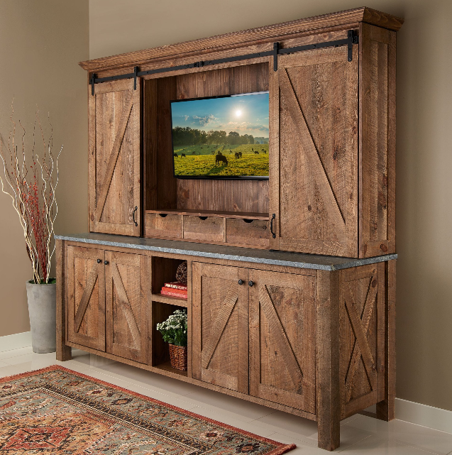 A wooden entertainment center with sliding barn doors and a flat screen tv