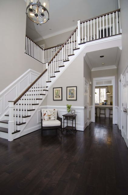 A hallway with a staircase and a chair